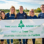 http://Sponsor%20volunteers%20posing%20with%20the%20National%20Tree%20Day%20banner。